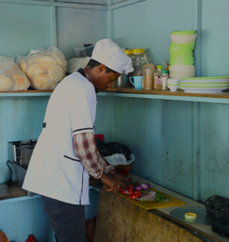 A person in a chef's hat cutting vegetables</p>
<p>Description automatically generated, Picture