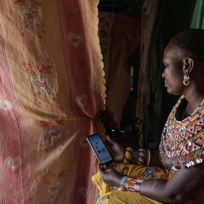 Samburu woman checks KAZNET app on her phone