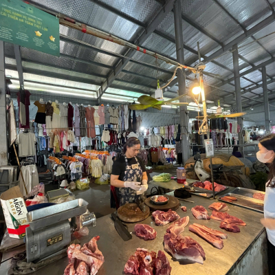 Dao Thi Duyen sells pork to a customer at Kim Lan market in Hanoi, applying improved hygiene practices learned through food safety training (photo credit: ILRI/Sinh Dang).