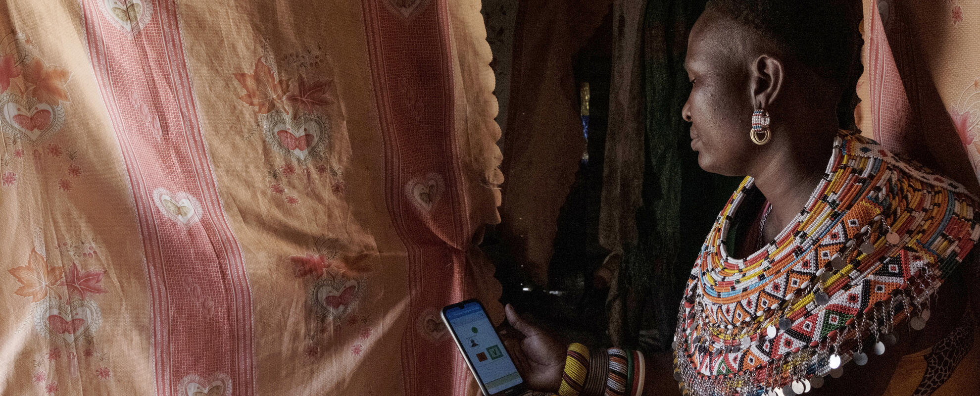 Samburu woman checks KAZNET app on her phone