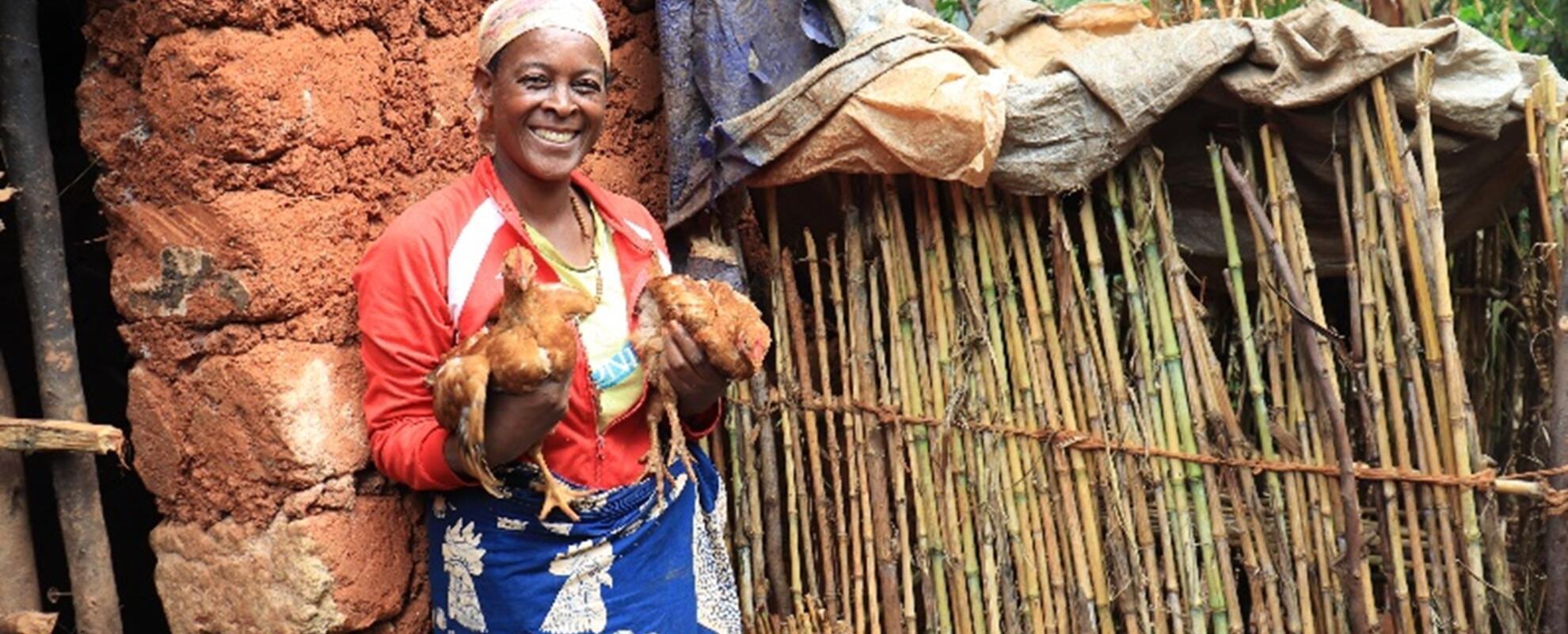 Candide Nshimirimana, a beneficiary from Masango Hill in Muramvya Province and a member of the Tuje Hamwe Twese I Muramvya Cooperative fondly holds her SASSO chicken